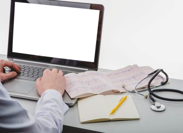 unrecognizable-medic-typing-laptop